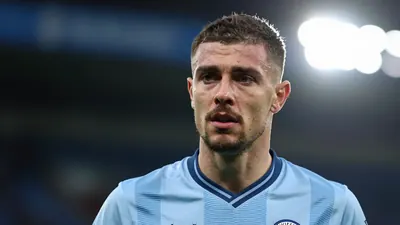 A 30-year-old Leicester City player, wearing a blue and white kit, looking concerned