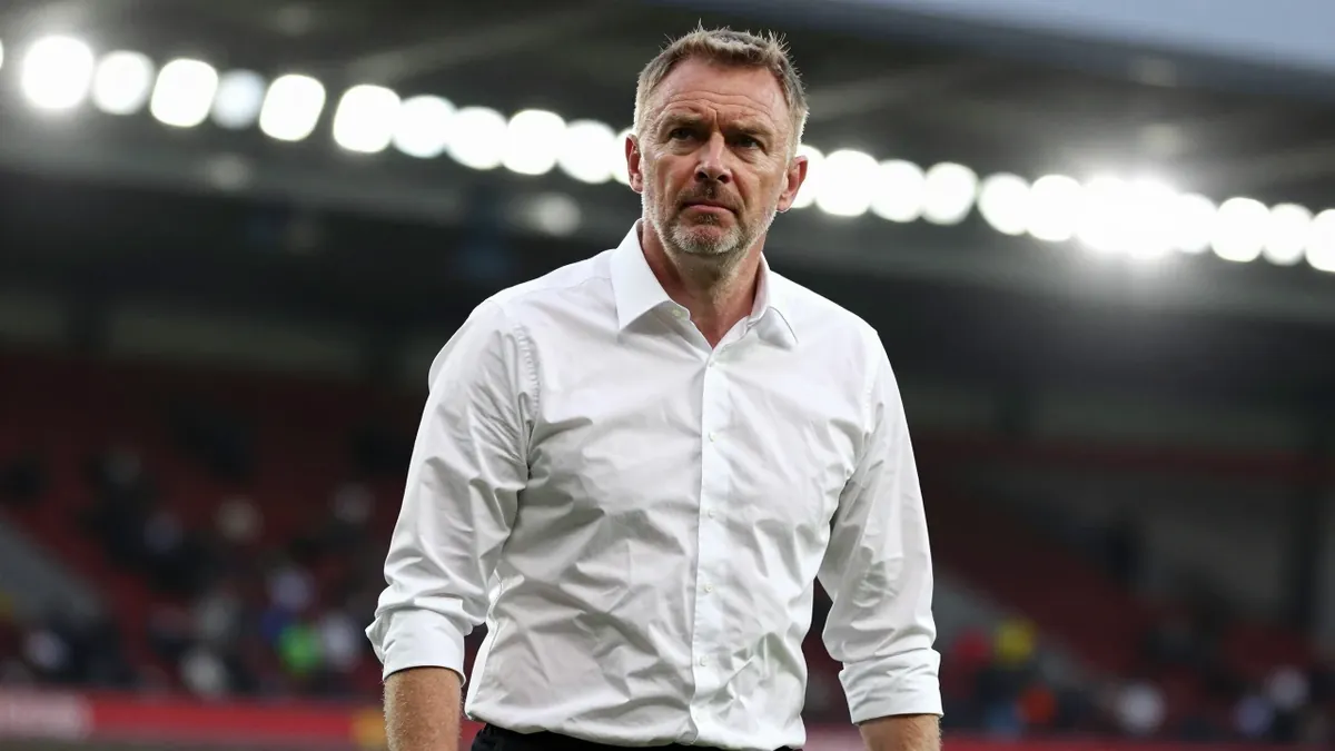Gary O'Neil, middle-aged manager in a clean white shirt and black shorts, head-and-shoulders shot, intense gaze and firm jaw