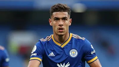 A close medium shot fills the frame with a young Leicester City midfielder of slight build and early twenties, face...